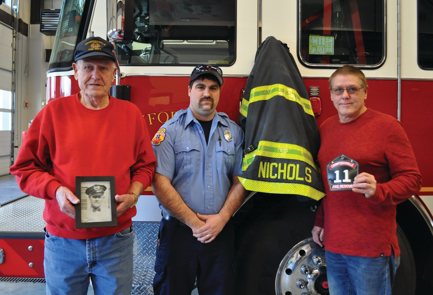 Seth Nichols, second from left, poses with his uncle, Brad Nichols, right, and grandfather, Richard Nichols, who is holding a picture of Seth’s great-grandfather Elijah Nichols.