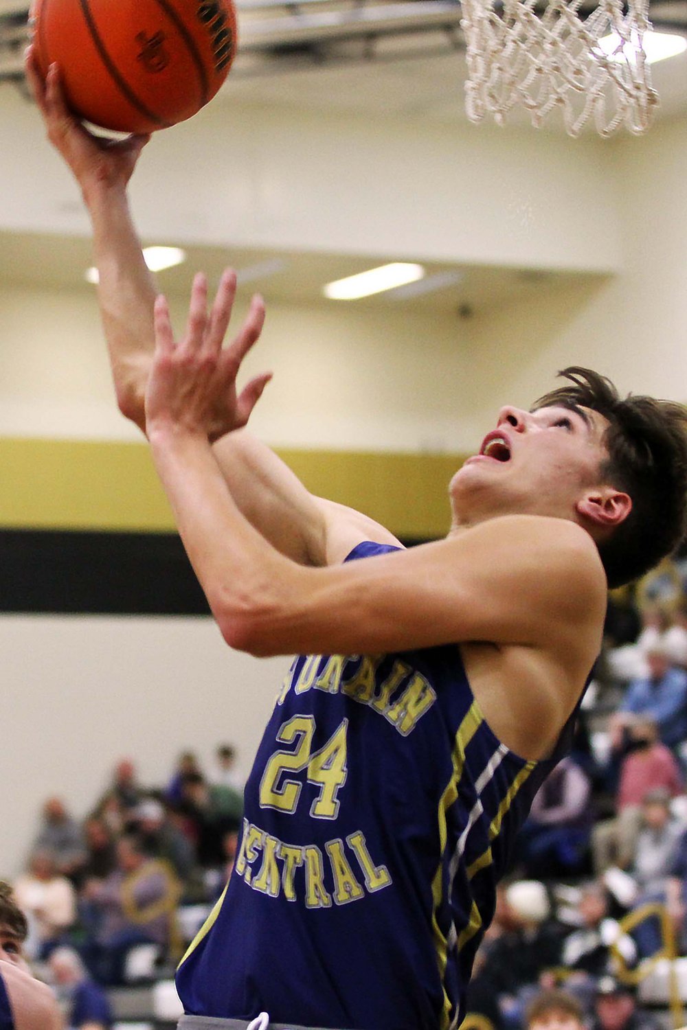 Isaac Gyler of Fountain Central scoops a reverse lay-up in the first quarter against Covington.