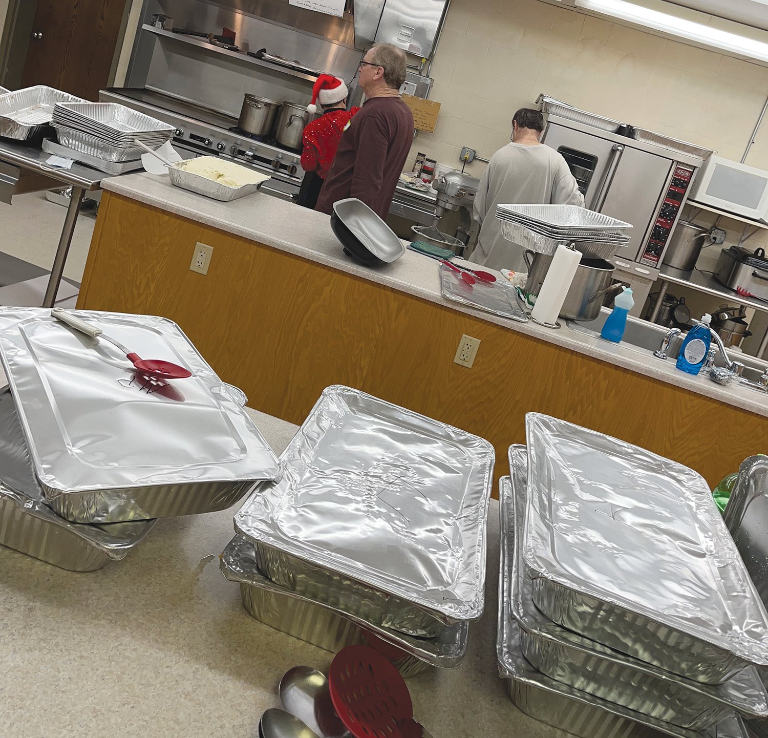 Volunteers work in the kitchen at First Baptist Church preparing meals.