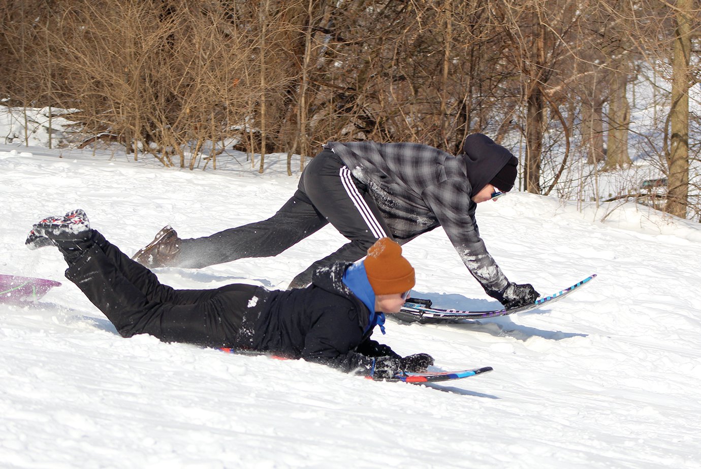 Ledger Lyons, 12, front, and Braxton Smith, 16, sled some freshies Friday at Milligan Park.