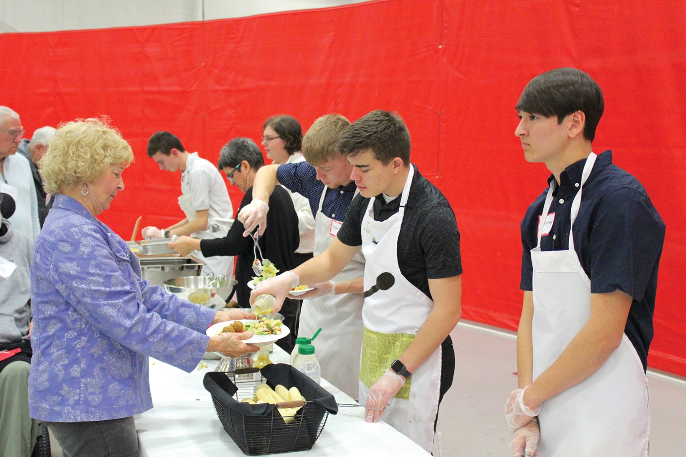 JoAnn Russell, left, is served Wednesday by Interact Club members Taishi Greiner, from right, Levi Brush, Trent Jones, Jacob Pike and Justin Bachmann, all seniors in the Southmont Interact Club, a teen satellite group of Crawfordsville Rotary. The five seniors arrived at Juniper Spoon, the day’s official caterer, early Wednesday morning to prepare the meal.