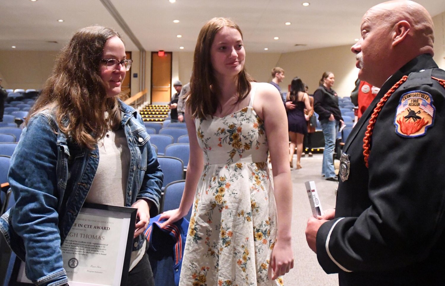 High school students Wyleigh Thomas (left) and Gracie Graham chat with Crawfordsville Fire Lt. Bryan Shaw after receiving special recognition during a West Central Indiana Career and Technical Education program Wednesday at Western Boone High School.