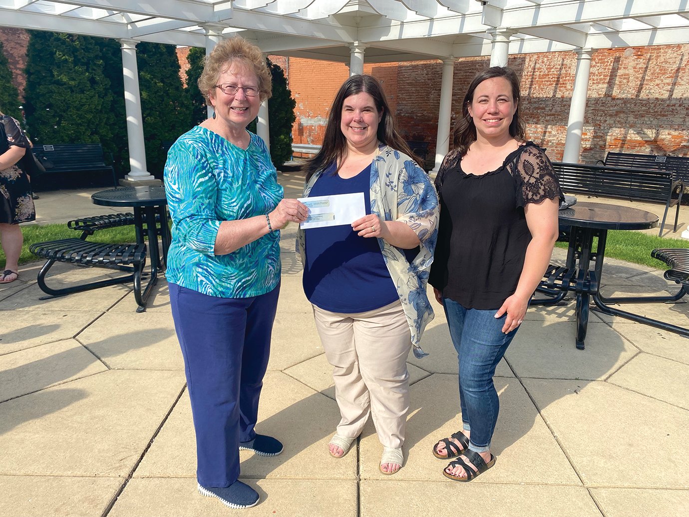 WLF Co-president Marilyn Spear, from left, presents a check to Rainbows & Rhymes Preschool representatives Emily Plummer and Brianne Pack Monday at Marie Canine Plaza.