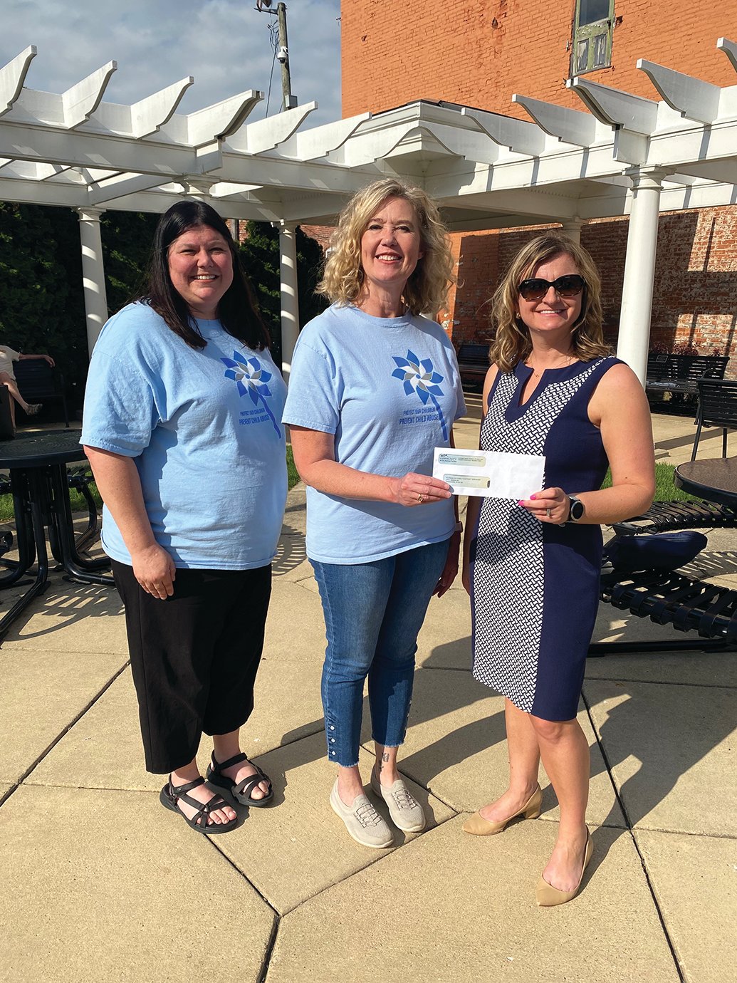 Starla Bradley, from left, Sherri Nield and Jessica Bokhart comprise the Healthy Families check presentation during a WLF event Monday at Marie Canine Plaza.