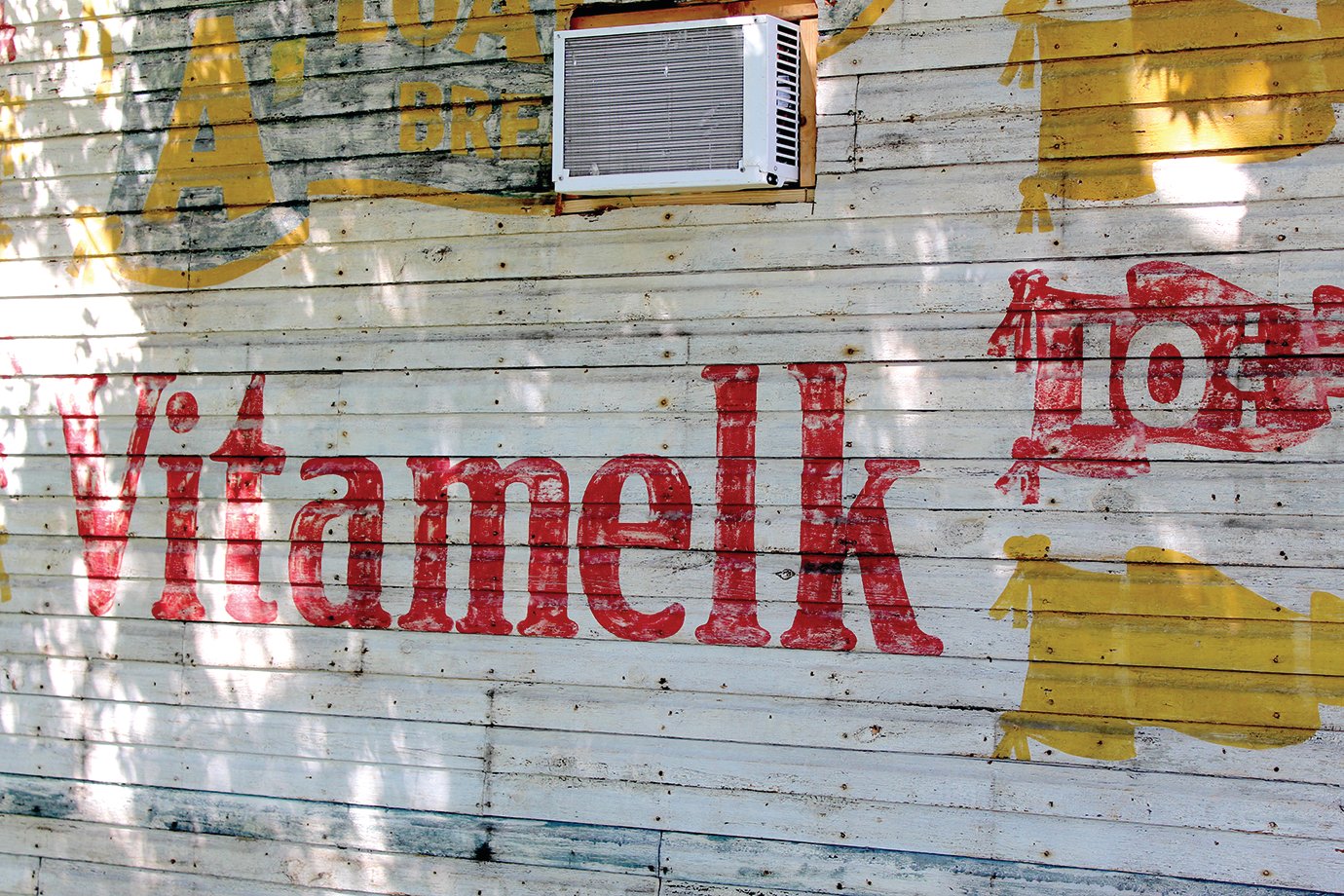 Vitamelk, an early 20th Century mulit-vitamin fortifier for feeds, again adorns the outside of a historic building at 1101 E. Main St. following decades behind particulate siding.