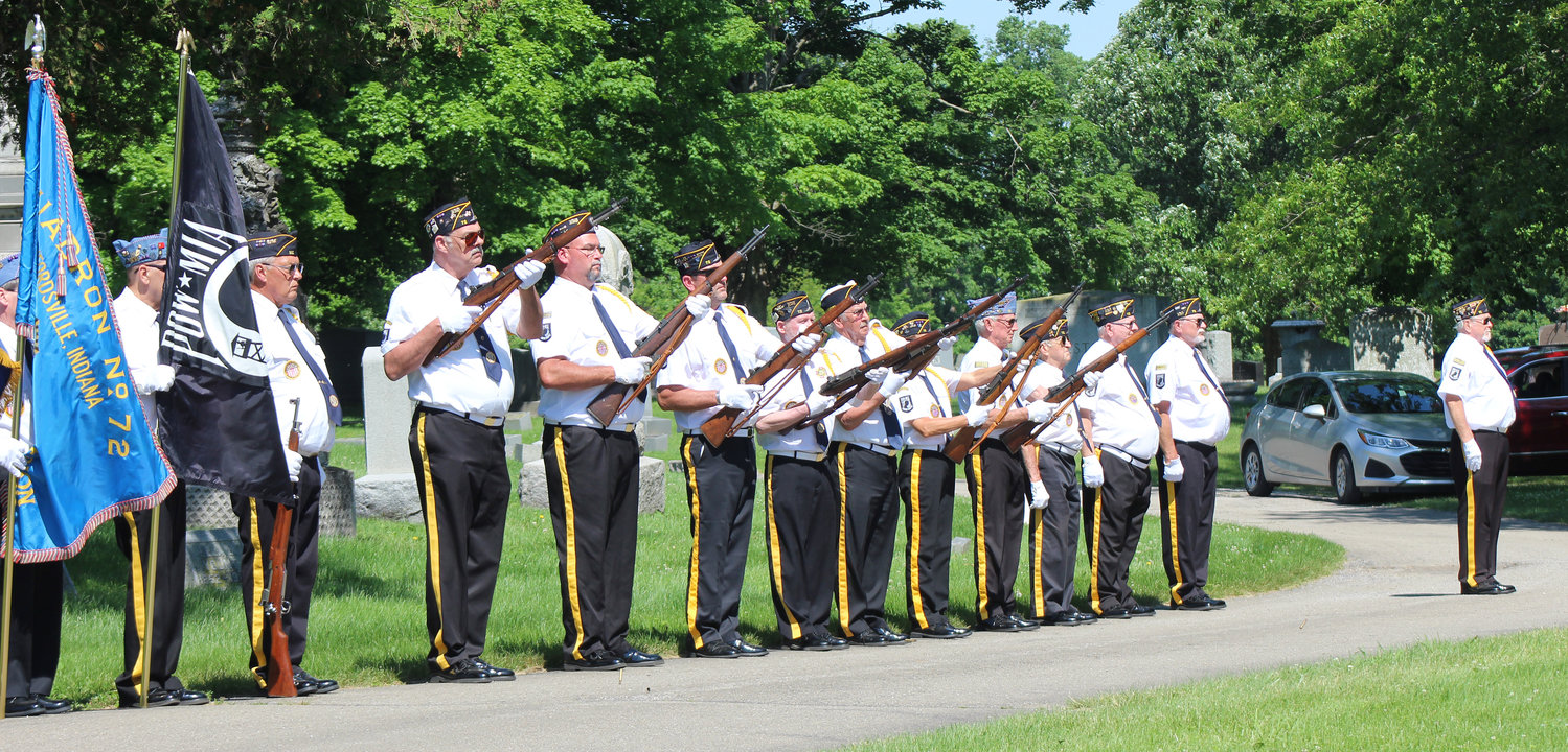Honor guard members perform a 21-gun salute.