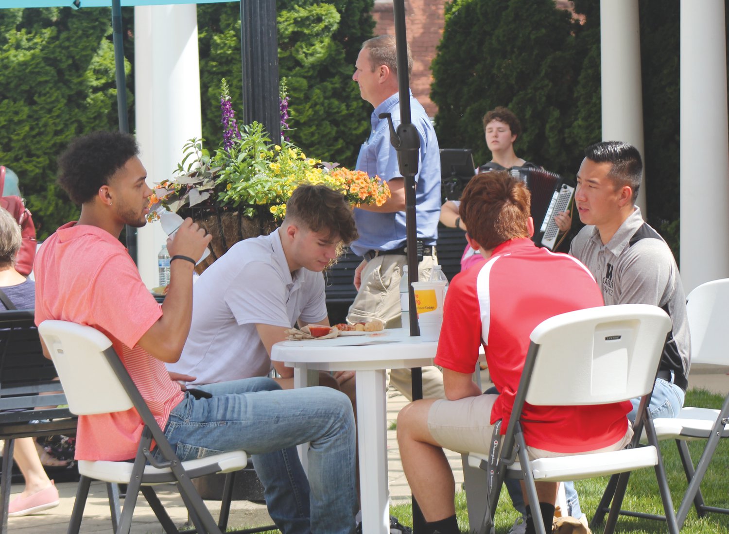 Several people, including a group of Wabash College interns, enjoy lunch served by Brothers Pizza.