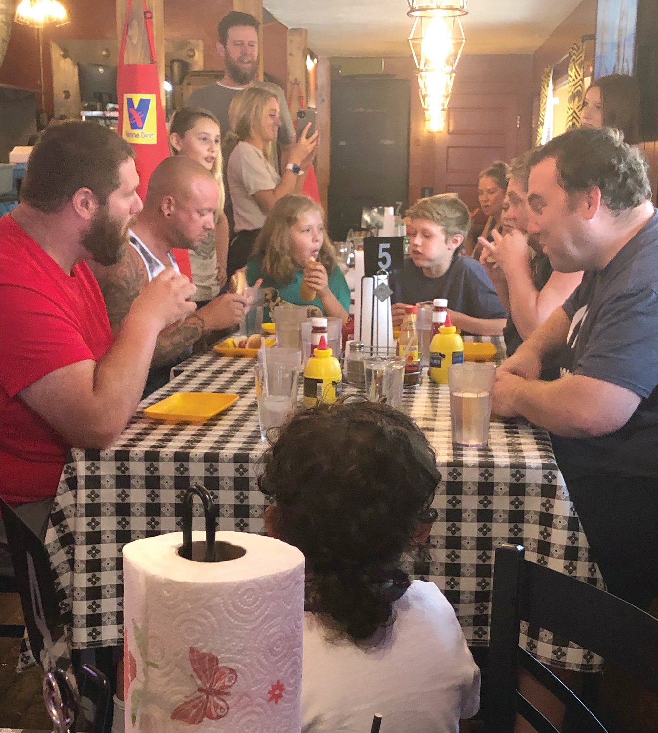 Contestants compete in the first-ever Harry’s Hotdog Eating Contest at the local restaurant.