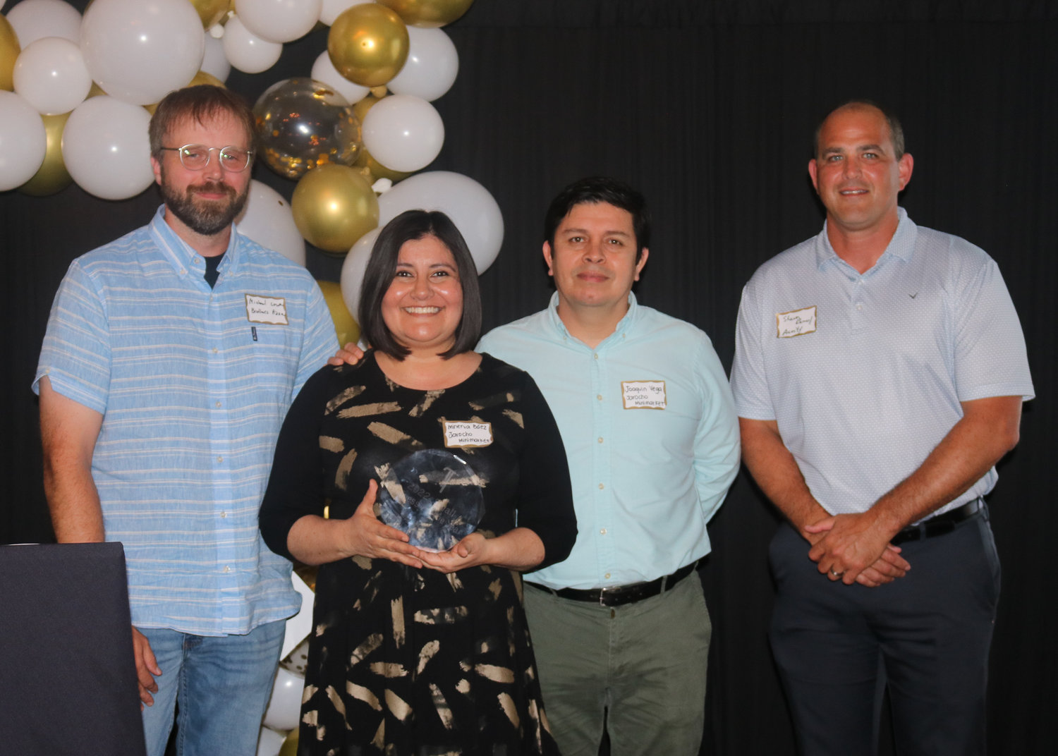 Minerva Baez and Joaquin Vega, center, accept the Small Business of the Year award. Also pictured is Brother’s Pizza owner Michael Lowe, left, and Shawn Ramey, Acuity Brands.