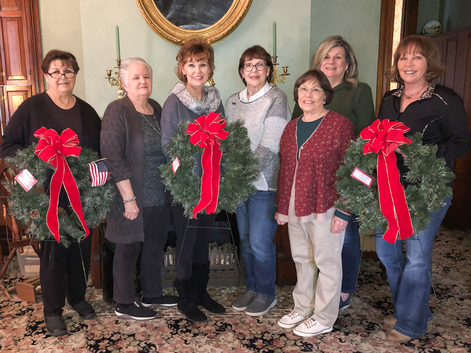 Members of the Dorothy Q Chapter of NSDAR recently decorated the chapter house inside and out. Members pose while holding three of the 19 Revolutionary War Patriot wreaths that are placed each year on graves of those patriots buried within Montgomery County.