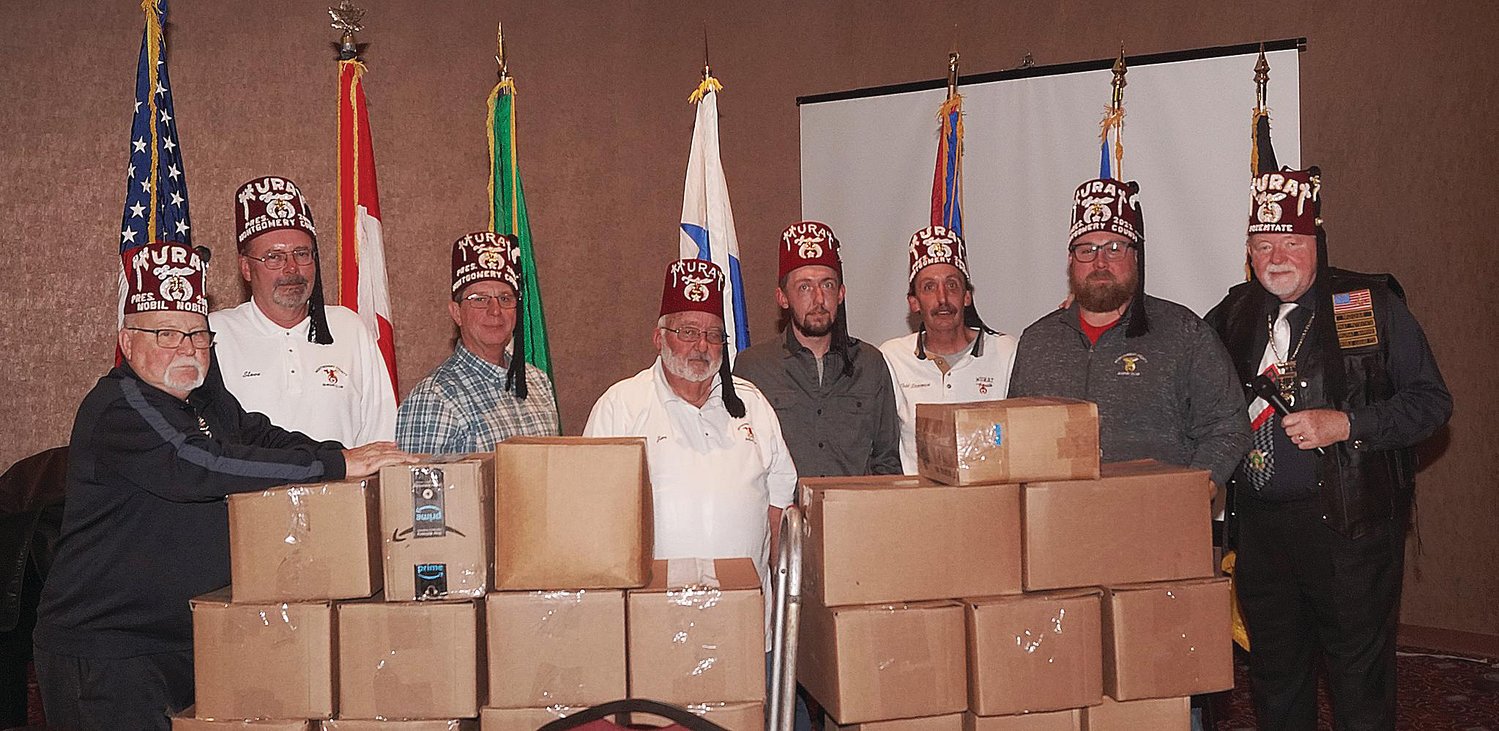 Photo Provided
The Montgomery County Shrine Club attended the November Murat Shrine meeting and donated $3,000 to each of the Shriner’s Hospitals in Chicago, Ohio and Lexington. They also donated $6,000 to the Murat building fund. The boxes pictured include 500 pounds of tabs, which are sold and proceeds used to buy items for the children in the hospitals. They also donated a Radio Flyer wagon to be given away at the Children’s Christmas party. The club wishes to thank all of Montgomery County for its generous support. If you have tabs that you would like to donate, they can be dropped off at Stevenson Automotive or the American Legion. Pictured are Joe Jones, Steve Lewis, Russell Switzer, Jim Stevenson, Chris Stevenson, Todd Stevenson, president Jeremiah Gleason and the potentate William Stanton.