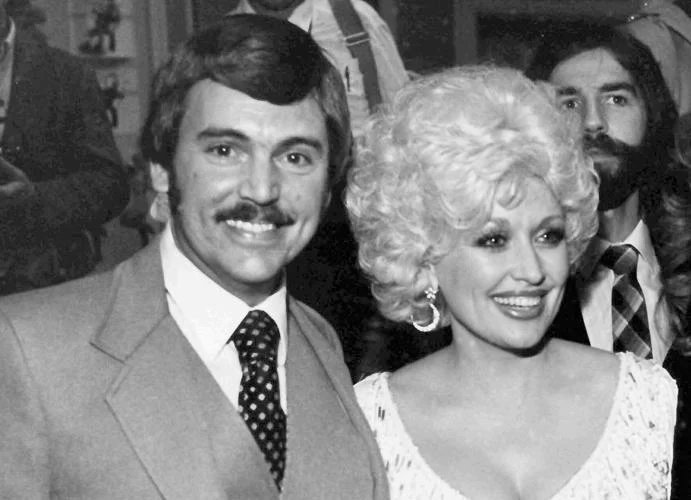 In this undated photo, Nashville, Tenn., newsman Joe Edwards, who has been writing the "Nashville Sound" column for nine years and knows everyone in the country music industry, poses with friend, actor and singer Dolly Parton at an awards reception. Edwards, who chronicled Tennessee news for more than 40 years as a newsman for The Associated Press and helped "Rocky Top" become a state song, died Friday, Feb. 3, 2023. He was 75.