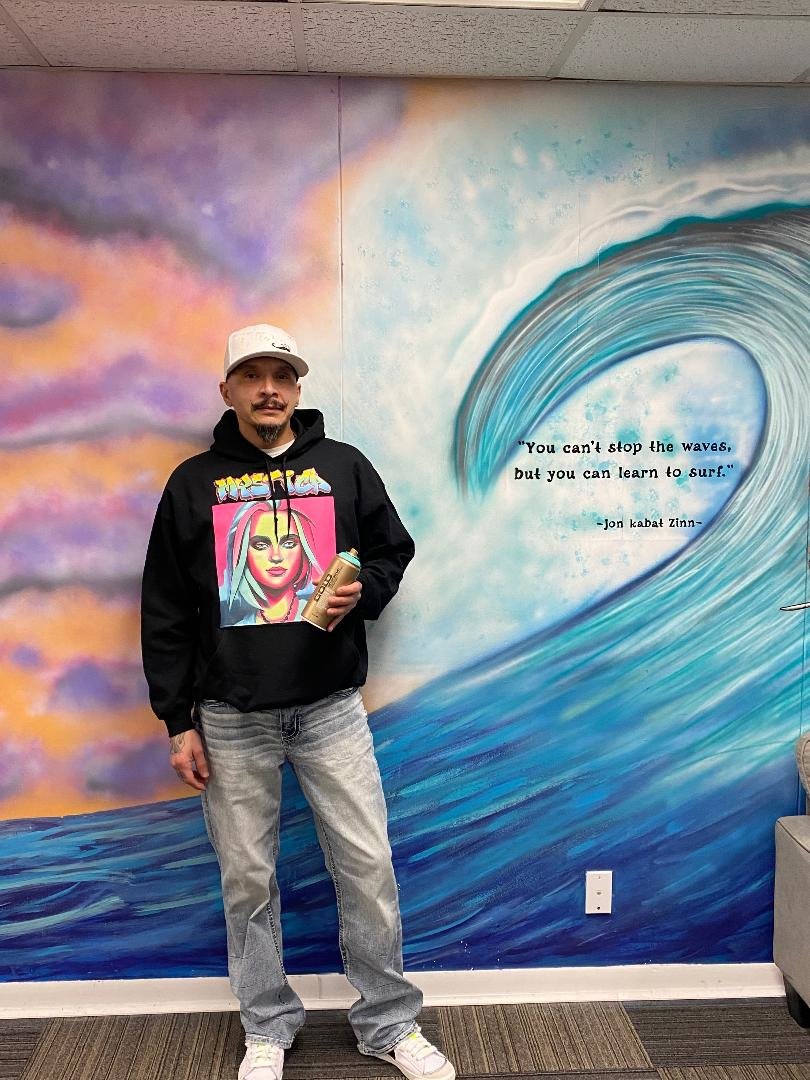 Ronnie "Flip" Walters poses by his mural at the Recovery Coalition.