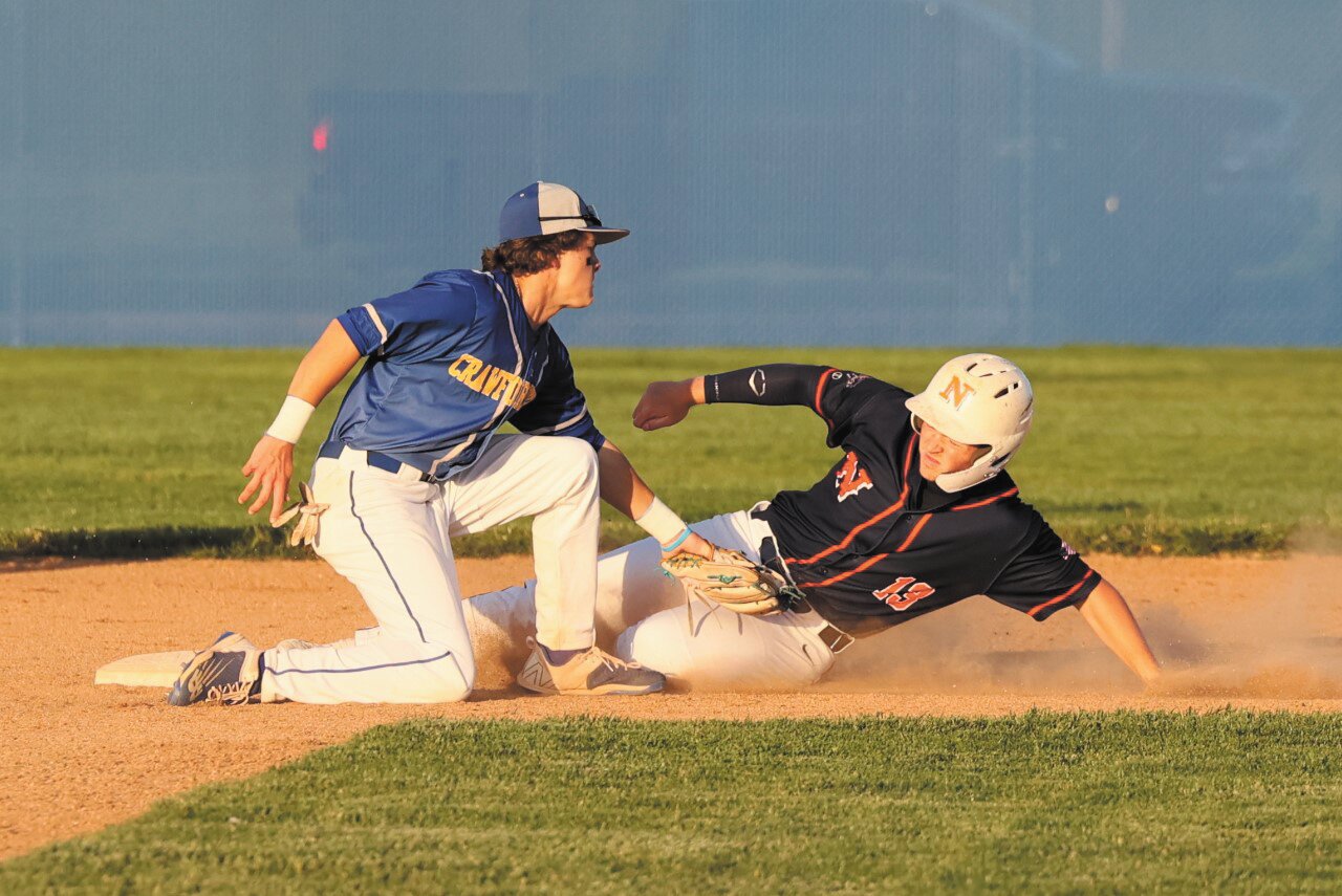 Brookes Walters slides in just under the tag of Jude Coursey during Crawfordsville’s 11-5 county and Sagamore Conference win over North Montgomery on Tuesday.