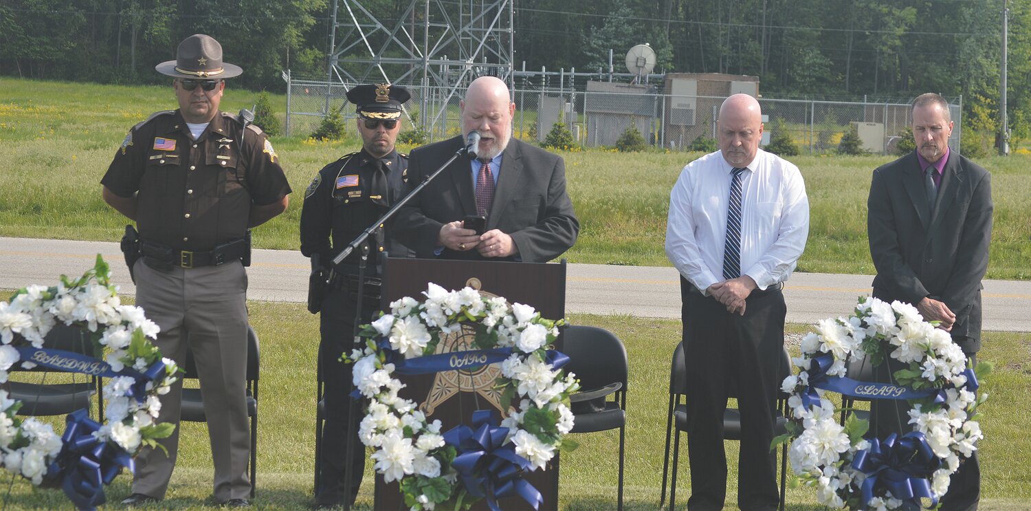 Alan Goff, chaplain for the Crawfordsville Police Department, leads a prayer Wednesday as part of the Police Week Memorial Service held outside the Montgomery County Jail on Memorial Drive. Also pictured, from left, are Montgomery County Sheriff Ryan Needham, Crawfordsville Police Chief Aaron Mattingly, Crawfordsville Mayor Todd Barton and Jamie Cevela, chaplain with the Montgomery County Sheriff's Office.