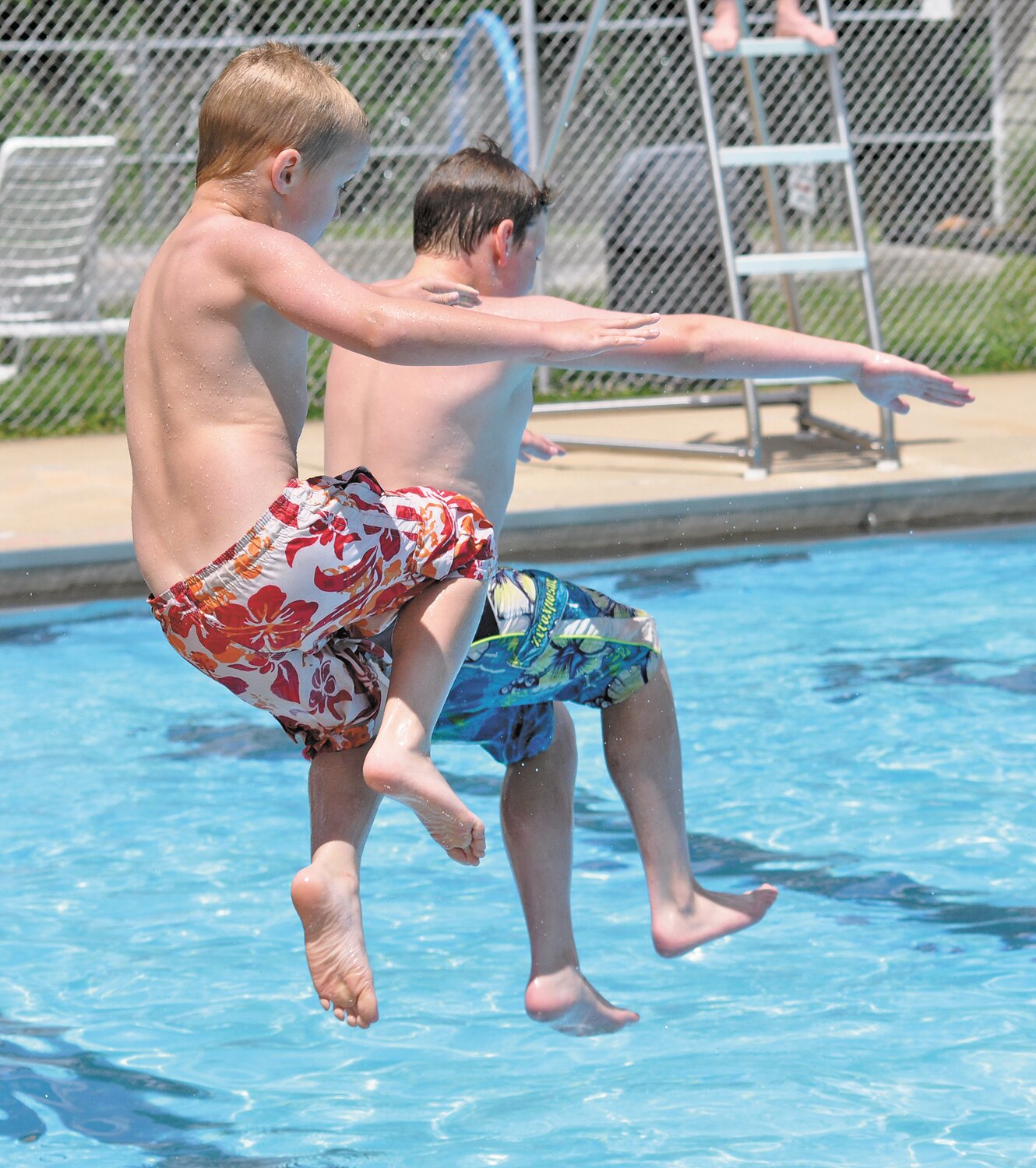 Boys jump into the Milligan Park Pool.