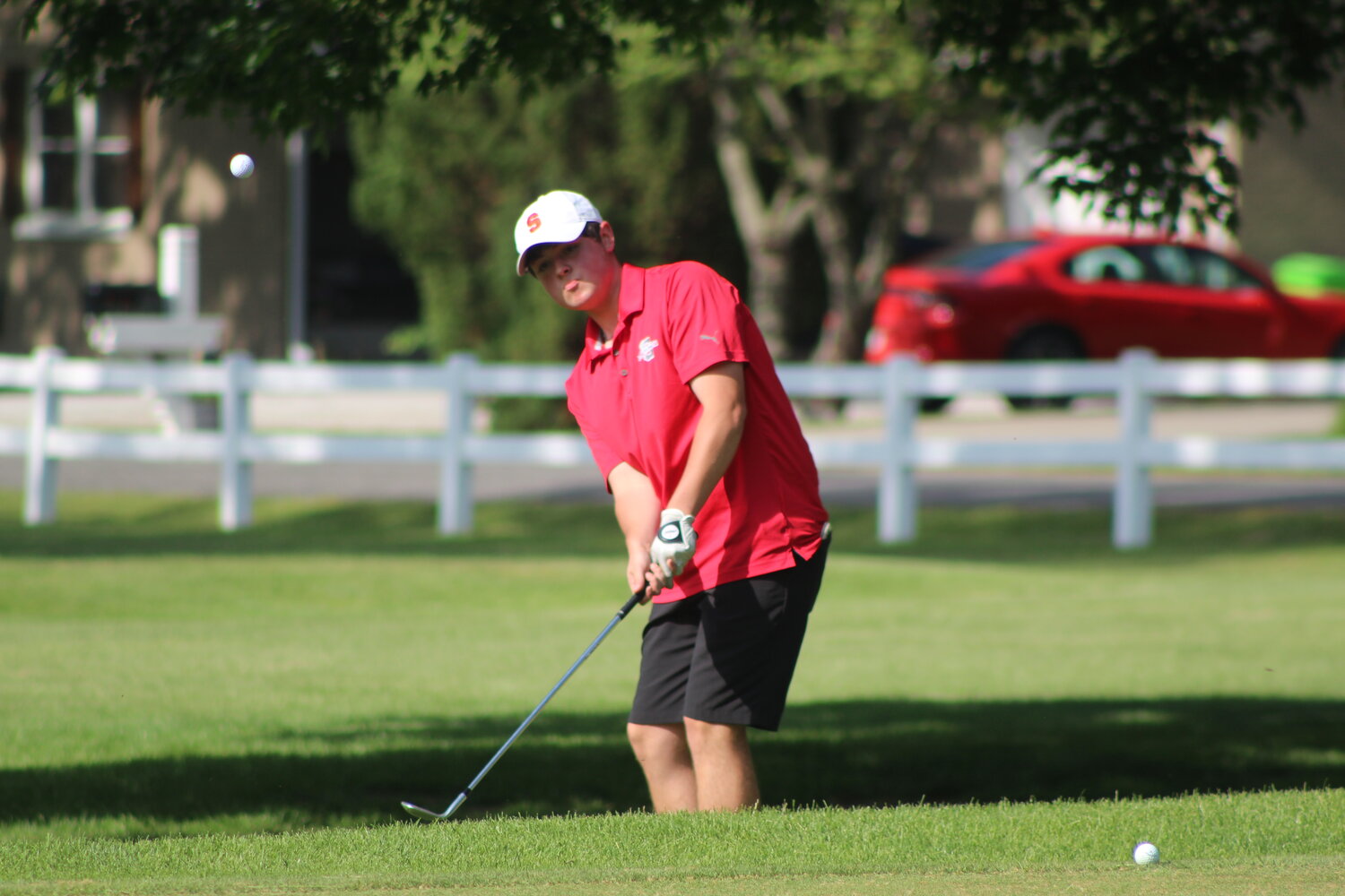 Senior Nolan Allen chips a shot onto the green during the County Meet. Allen fired an 83 to help the Mounties clinch the county title.