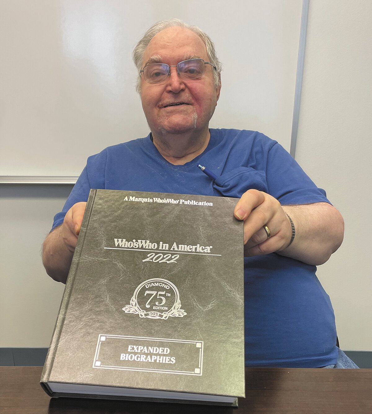 John Oilar poses with the Marquis Who's Who in America Diamond 75th Year Edition.