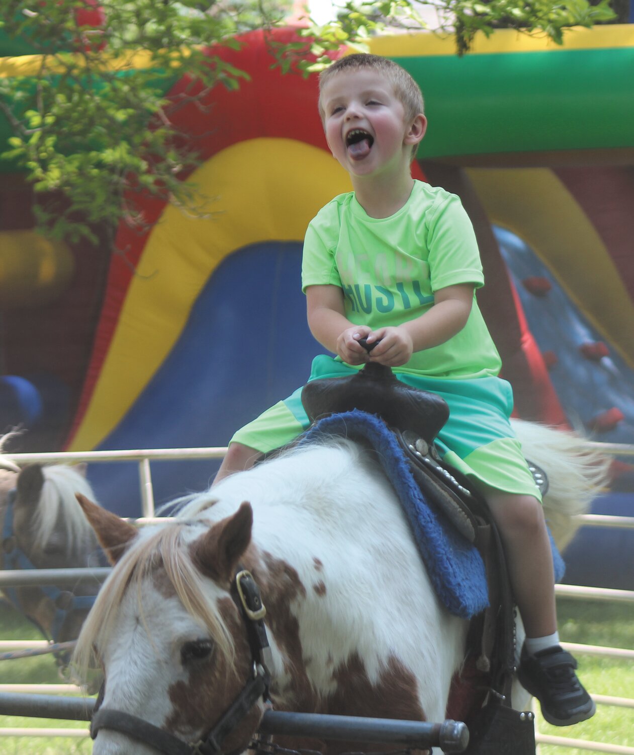 Kaine Jones, 4, couldn't hold back his happiness while riding a pony in the Children's Area.