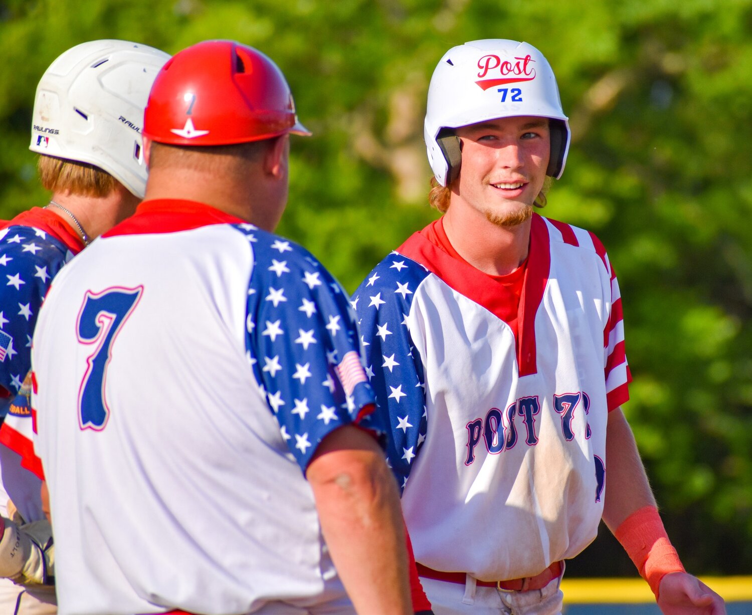 Kaiden Underwood talks with Post 72 coach Kyle Proctor after he gets on base.