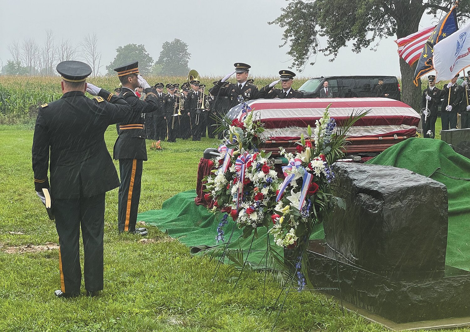 Officers salute the casket of Retired Major General Richard Chastain.