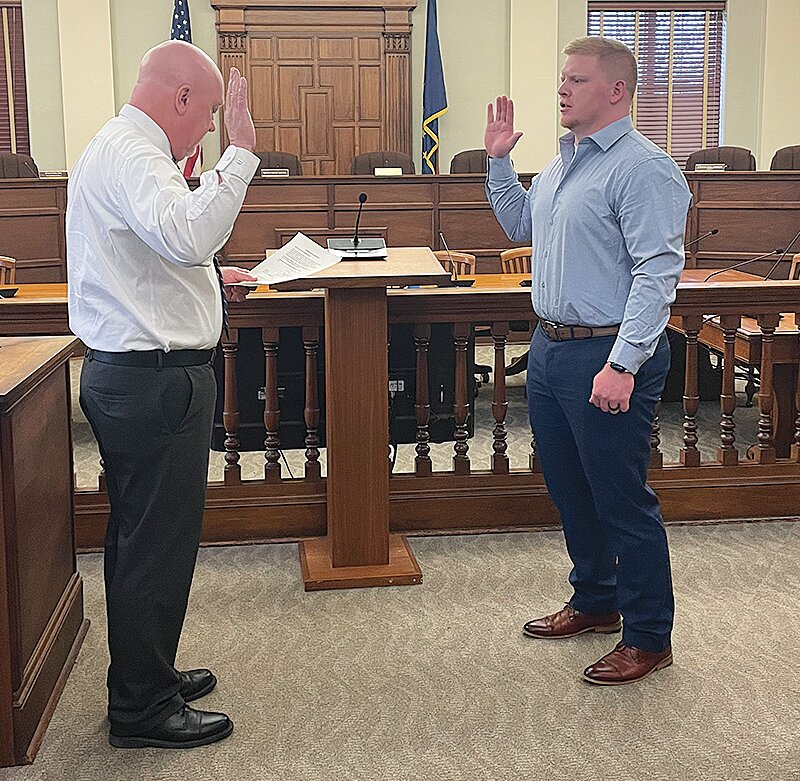 Mayor Todd Barton, left, administers the oath of office Wednesday to newly hired police officer Tanner Dreher.