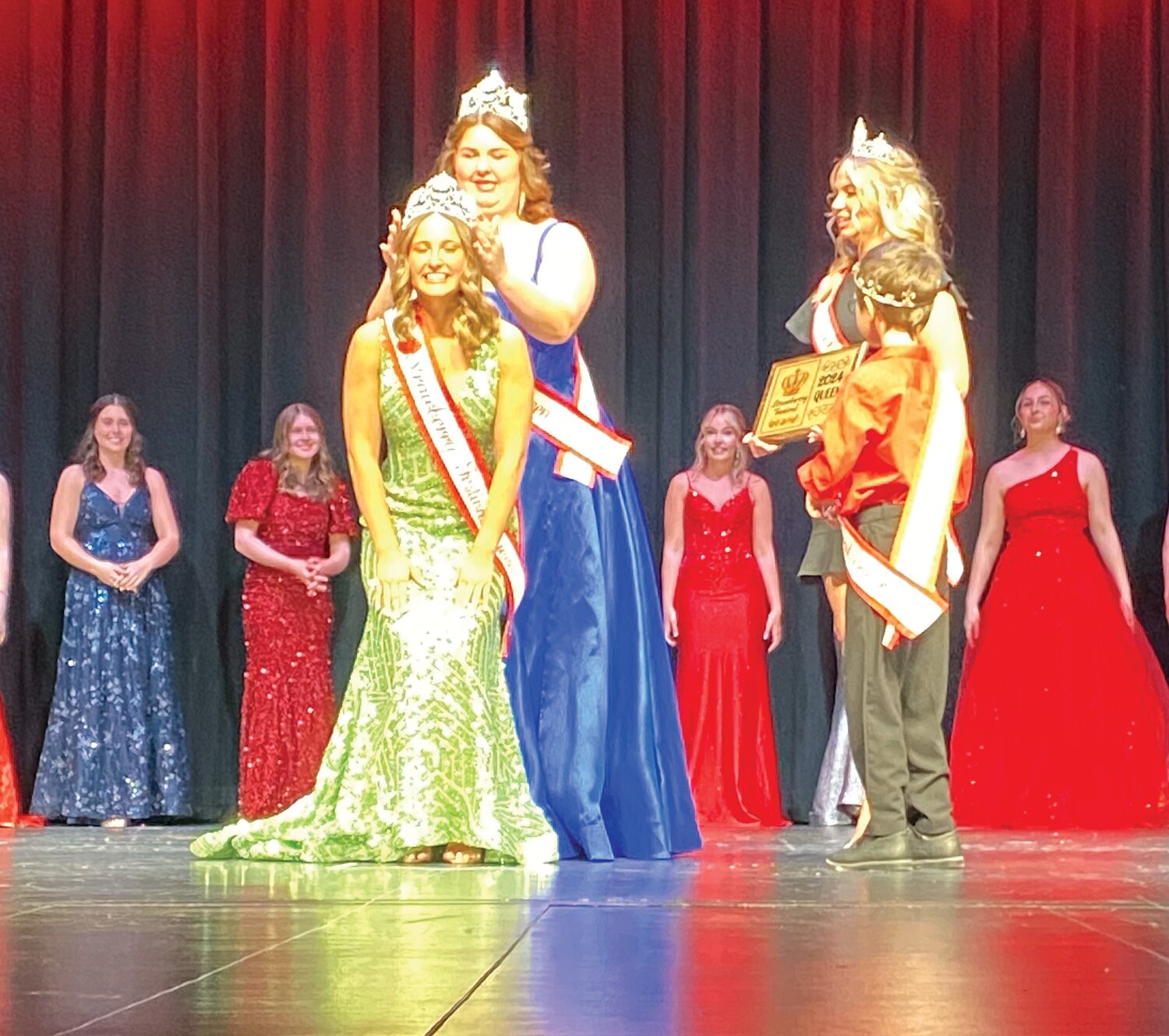 Peri McClaskey is crowned the 2024 Strawberry Festival Queen on Saturday at Crawfordsville High School by outgoing queen Kelsey Thompson.