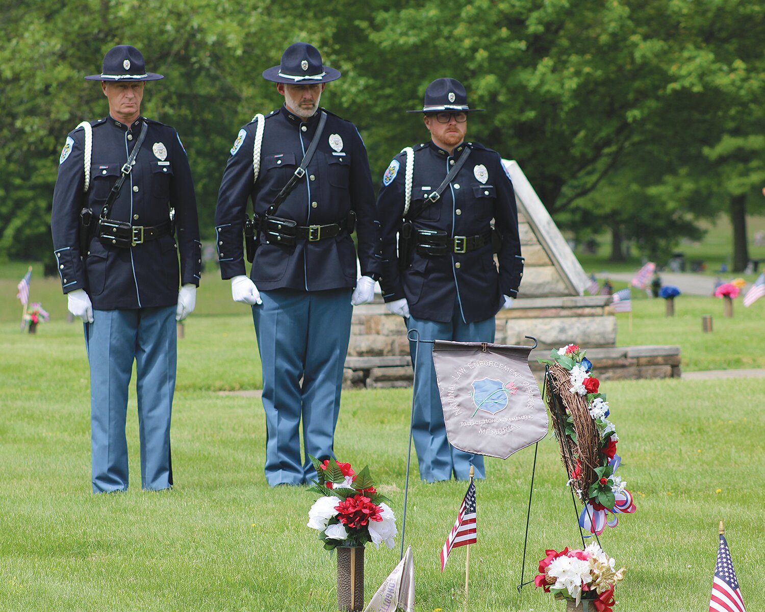 Officers pay their respect Wednesday at Oak Hill North Cemetery after laying a wreath on the grave of Leslie Oaks, a county deputy who was killed in the line of duty in May of 1982.
