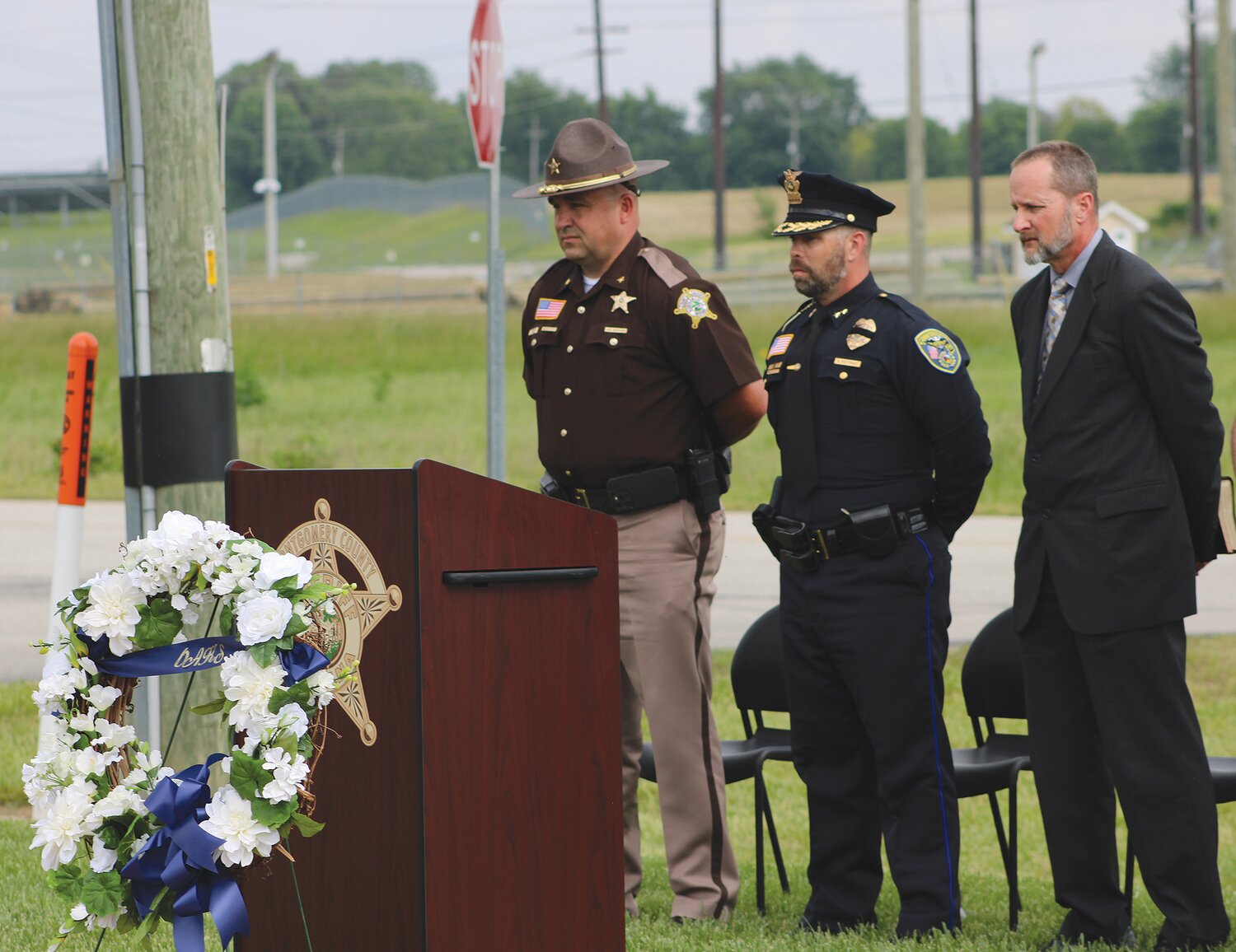 Montgomery County Sheriff Ryan Needham, Crawfordsville Police Chief Aaron Mattingly and MCSO chaplain Jamie Cevela stand during the memorial ceremony outside the county jail.