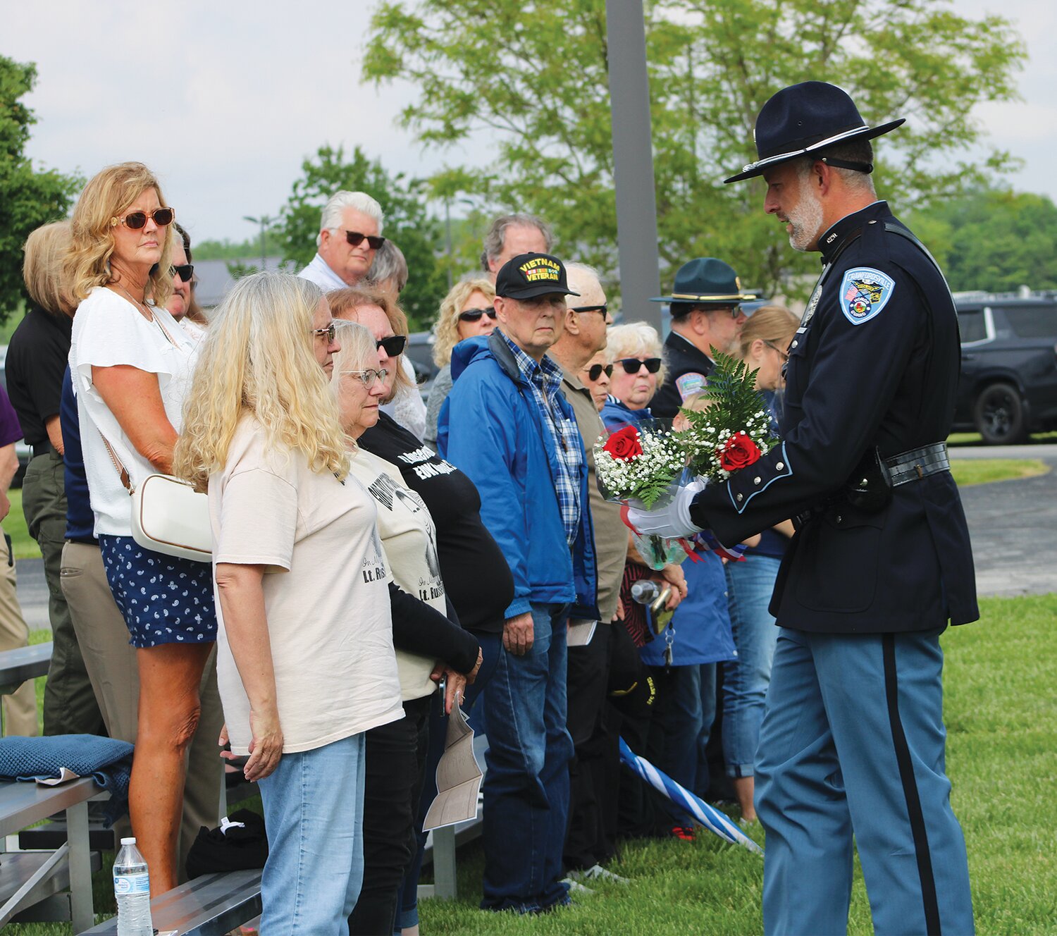 Crawfordsville Police Lt. Matt Schroeter presents flowers to members of Lt. Russell Baldwin's family.