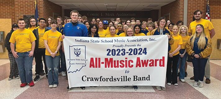 Members of the CHS band program pose with a banner from the Indiana State School Music Association.