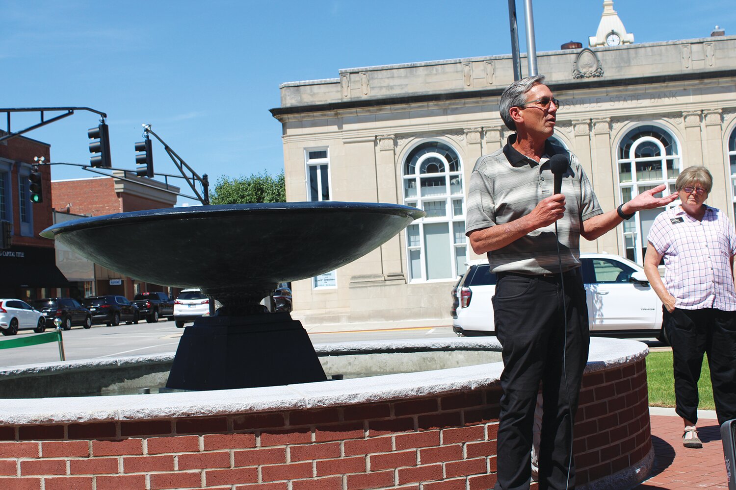 Tom Fansler, president of Tiii Environments/Smock Fansler Corp., talks about the new fountain his company helped create at Marie Canine Plaza. Also pictured is Sue Lucas, director of Crawfordsville Main Street.
