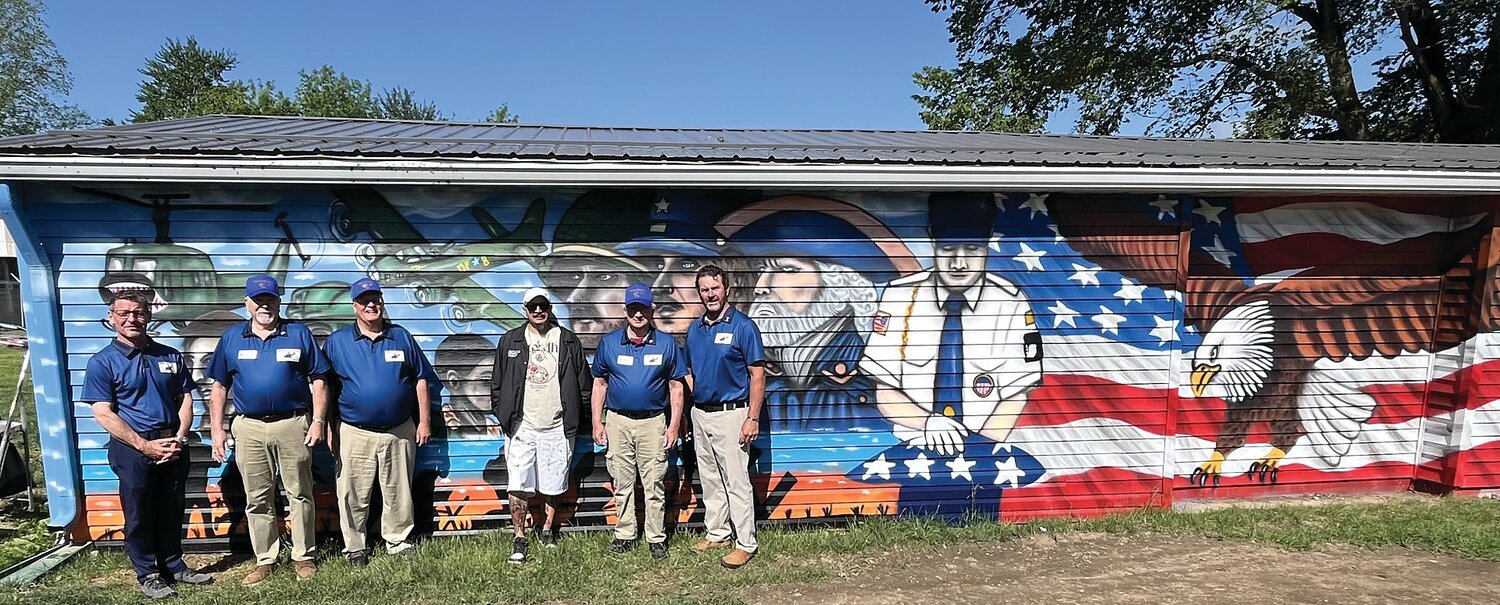 Veterans Memorial Park Board Member John Douglas, VMP Vice President Mike Spencer, VMP Board Advisor Mark Eutsler, Mystica Spray Artist Ronnie Walters, VMP Secretary Bill Durbin and VMP President Kevin Cobb stand in front of the newly complete Veterans Mural created by Walters as a backdrop to the park. The mural depicts military branches throughout American history. VMP is organized as a not-for-profit corporation and is recognized as tax-exempt by the IRS under Section 501(c)(3). Its mission is “Honoring All Veterans.” Various parts of the park and its operation are available for sponsorship and underwriting, including purchasing bricks that will surround the center monument. Engraved bricks will recognize veterans and those who support veterans. More information is available on the park’s Facebook page—“Veterans Memorial Park – Crawfordsville.”