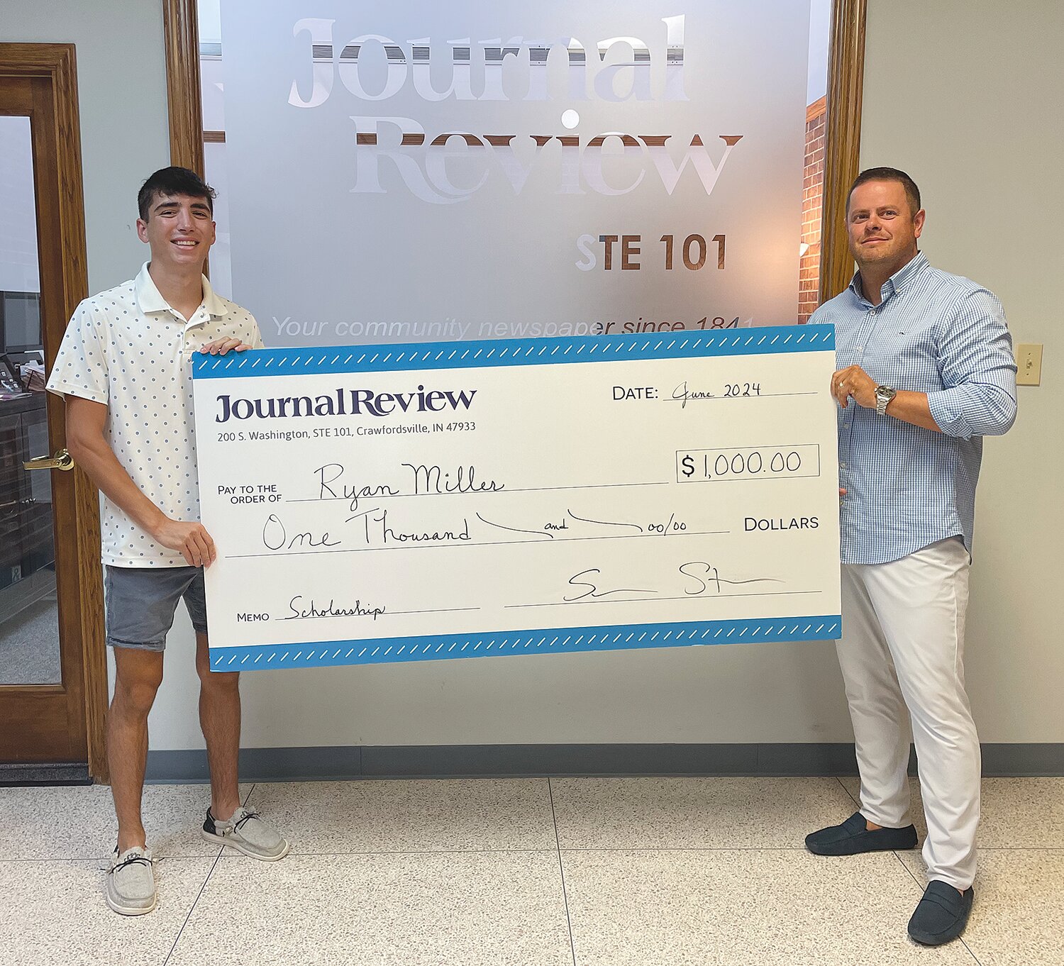 Ryan Miller, left, was selected as a 2024 Journal Review Scholar and received a $1,000 check from Journal Review Publisher Shawn Storie.
