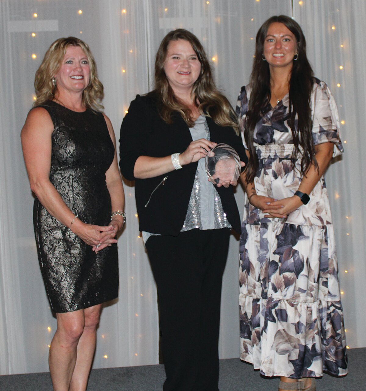 Jessica Harris, center, was awarded the 2024 Woman of the Year Award. She is pictured with Stacy Sommer, left, and KyLee Risner.