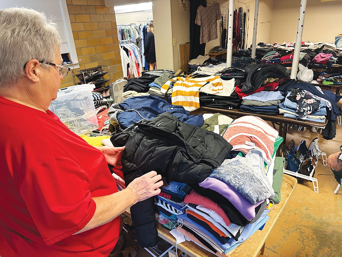 Bev Haniford checks coat donations for tag size.