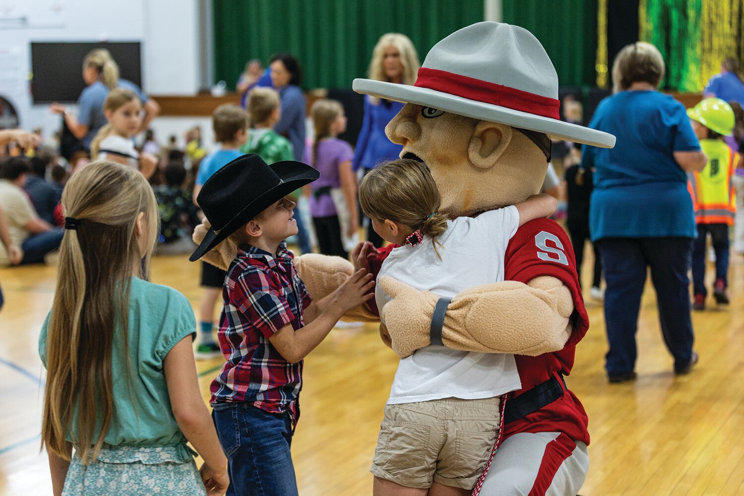 BELOW: Students hug the Mountie, South Montgomery Schools’ mascot, during the celebration.