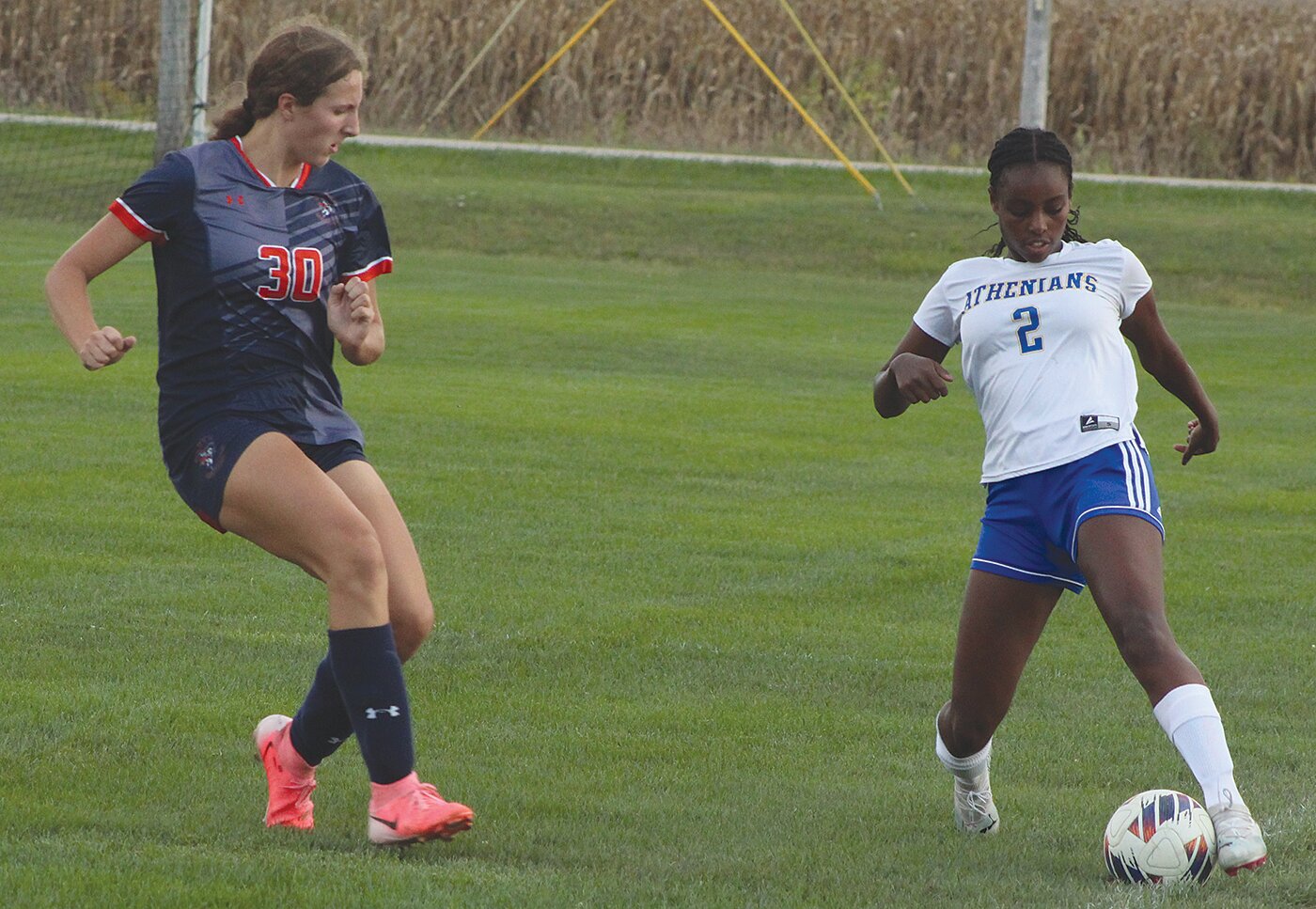 Crawfordsville’s Maesa Horton saves the ball from going out of bounds while Anna Cain defends.