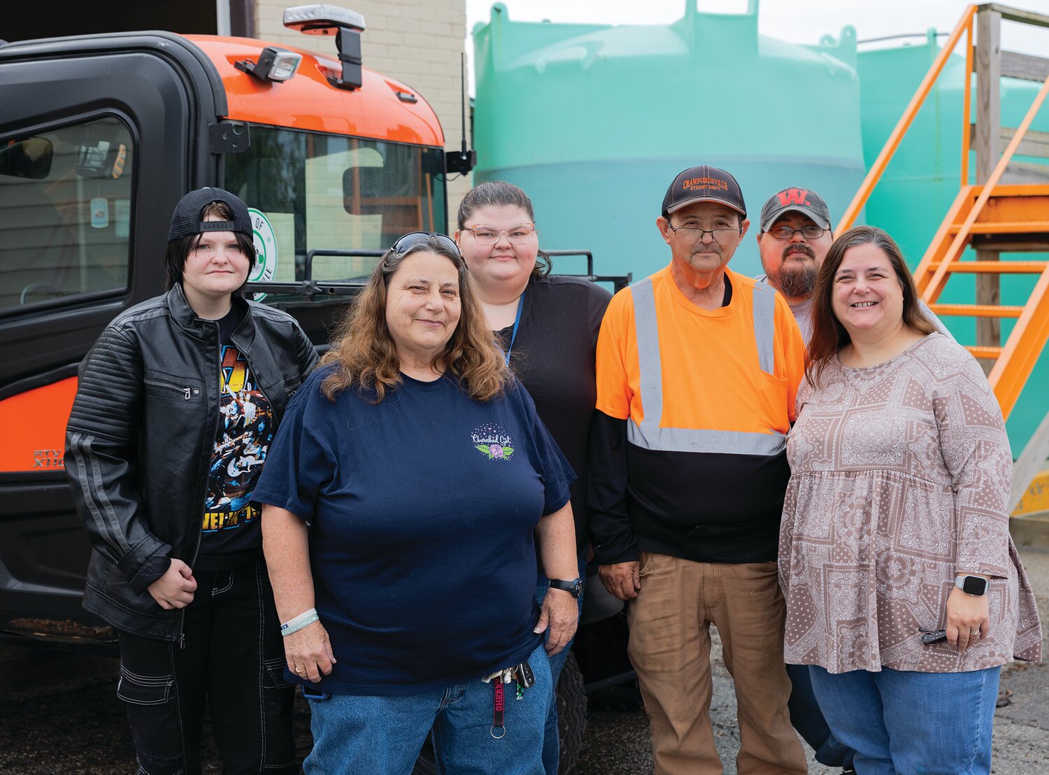 Larry Hunt and his family pose in front of a work truck at his work-hosted retirement party on Friday.