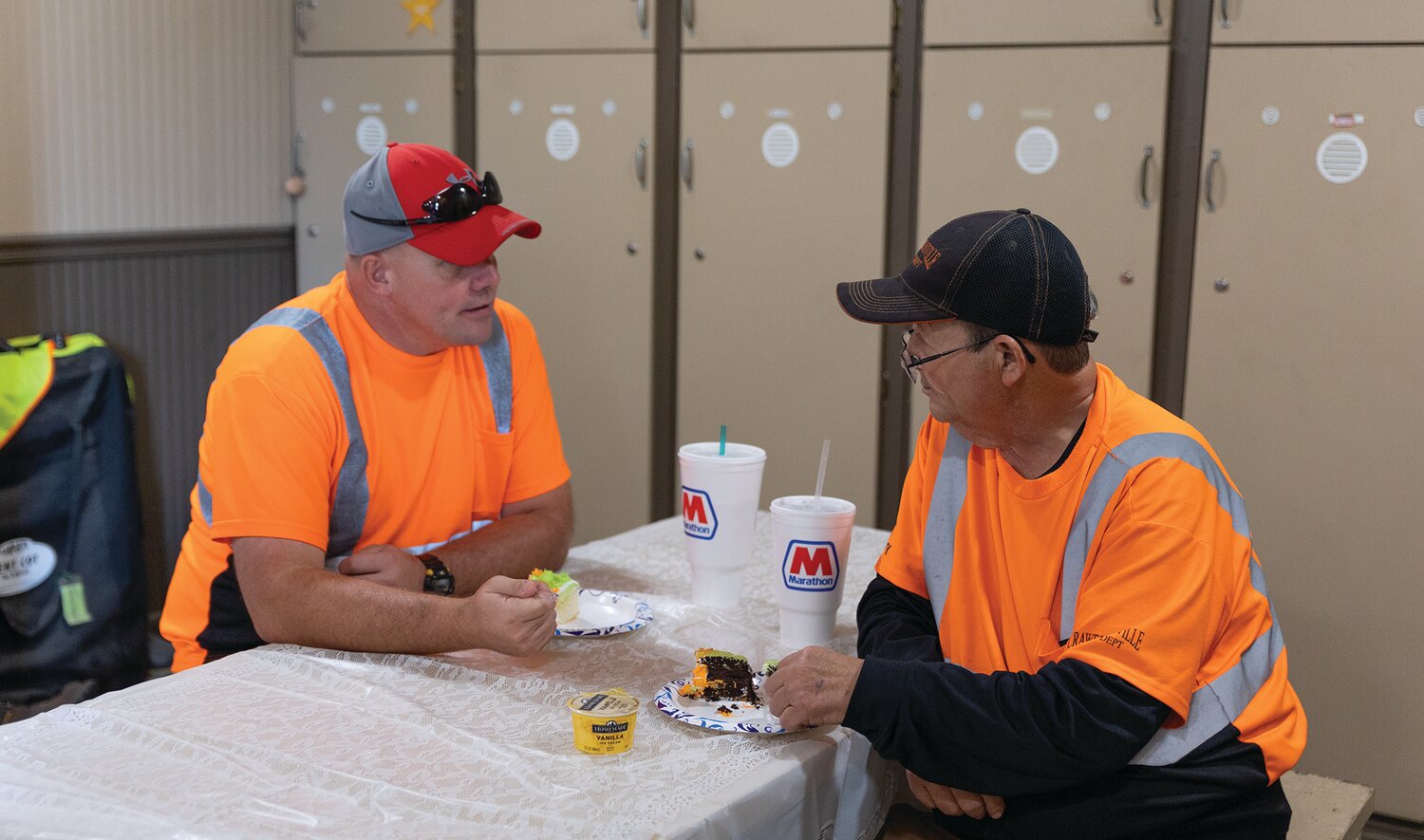 Larry Hunt and Chad Hodges sit together during Hunt's retirement celebration at work on Friday.