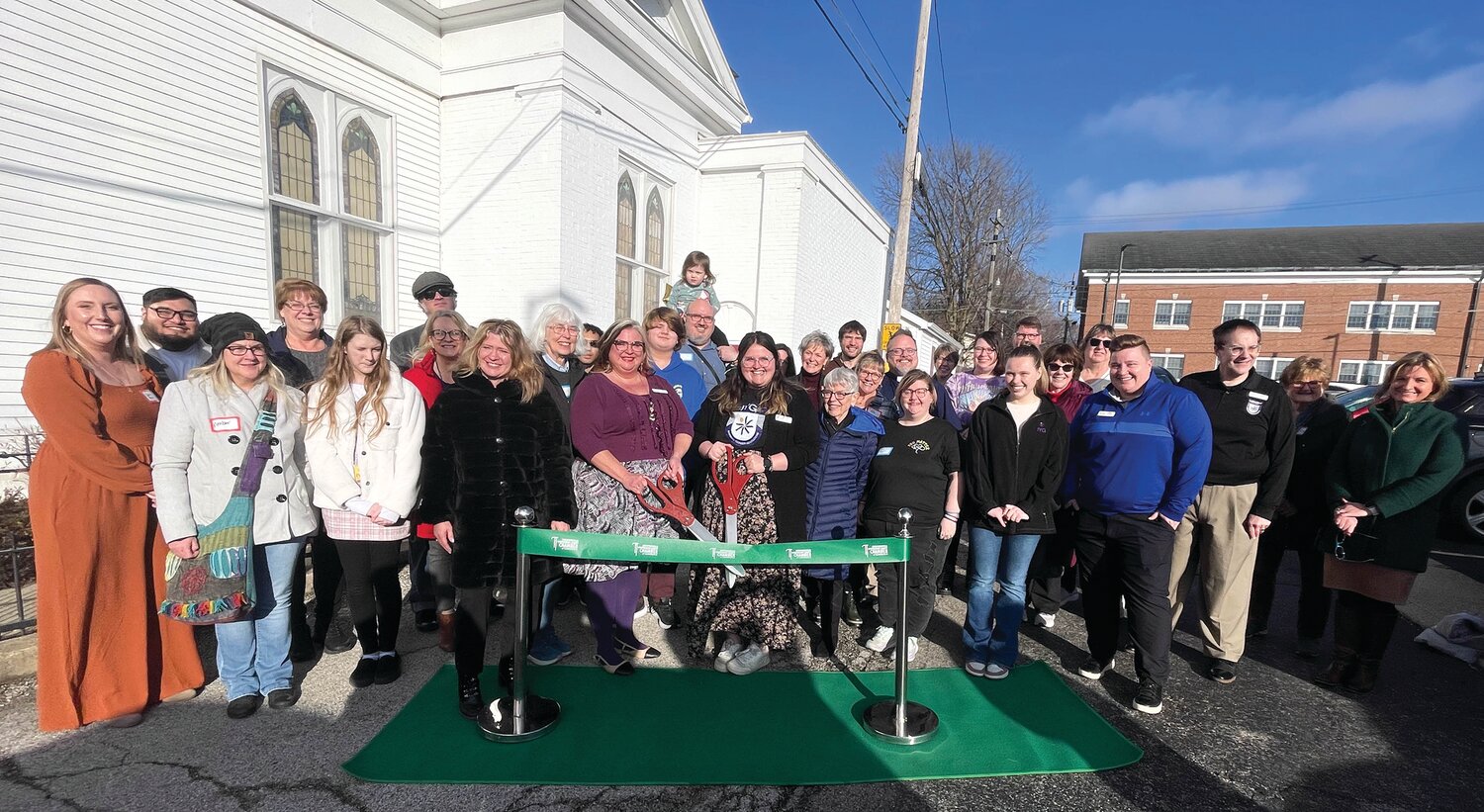 IYG client services center supervisor Kara Riley and Bekah Farrel cut the ceremonial ribbon Thursday for the re-opening of the IYG Center. The event was supported by the Crawfordsville/Montgomery County Chamber of Commerce and attended by volunteers and other IYG members and staff.