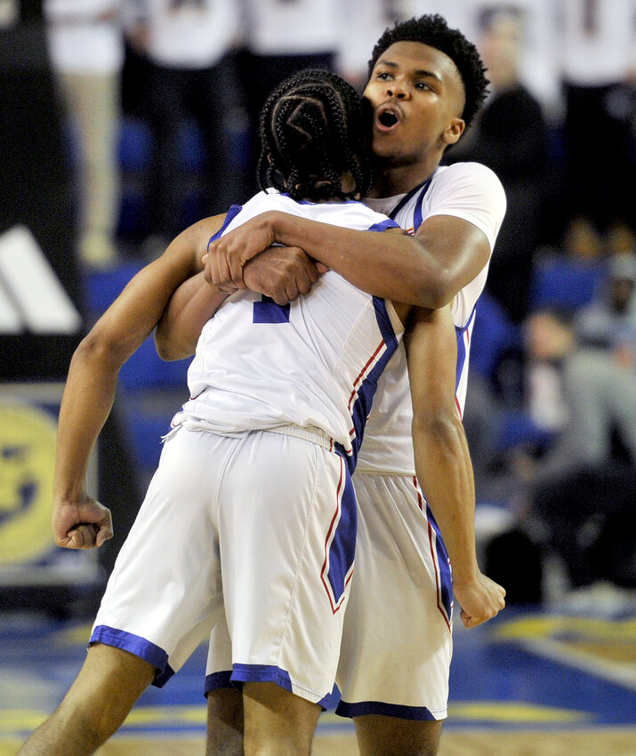 Dorell Little celebrates with Dover teammate Denim Perkins after they won the DIAA state basketball championship game against Salesianum 56-53.  SPECIAL TO THE DAILY STATE NEWS/GARY EMEIGH
