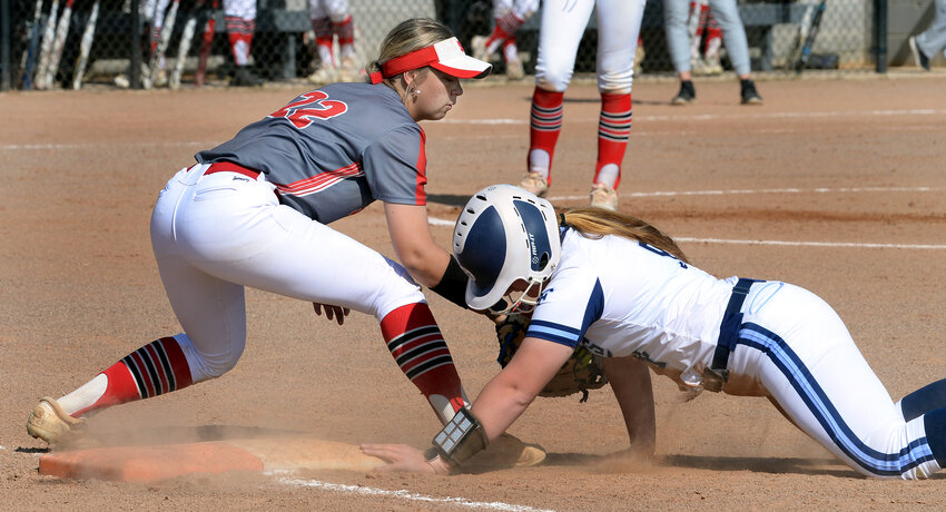 Bayli Glanden of the Spartans gets back to first base on a pickoff attempt with Smyrna’s Hailey McCutchan makes the late tag in a game earlier this season.  SPECIAL TO THE DAILY STATE NEWS/GARY EMEIGH