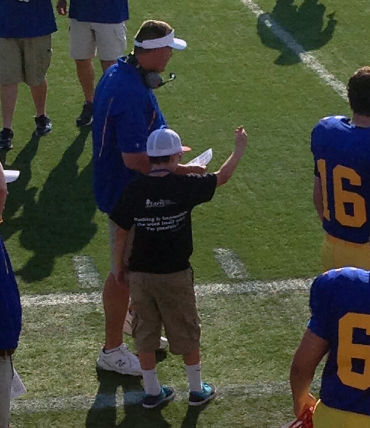 Jacob Tiberi as a youngster with Blue coach Marvin Dooley on the sidelines at the 2016 Blue-Gold All-Star Football Game. SUBMITTED PHOTO.