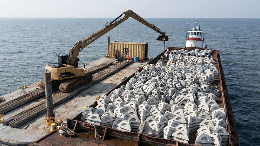 A fully-loaded barge of reef balls, pyramids and pipe &ldquo;spuds down&rdquo; begins the work of deployment onto the Janes Island Artificial reef site in Tangier Sound. Coastal Conservation Association Maryland is the fiscal agent the Maryland Artificial Reef Initiative (MARI) which includes over 60 private and government partners, and works directly with Maryland DNR.