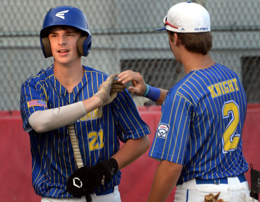 Colby Rall of Camden-Wyoming is congratulated by teammate Blake Knight after he scored from second on a double by Ethan Wisler in the second inning of the Senior League baseball District I championship game played at Smyrna.  SPECIAL TO THE DELAWARE STATE NEWS/GARY EMEIGH