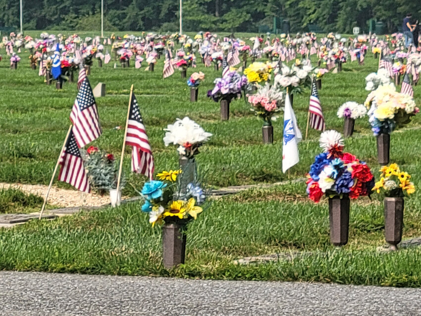 A field of markers with vases, flags and flowers is shown at the Delaware Veterans Memorial Cemetery in Bear.