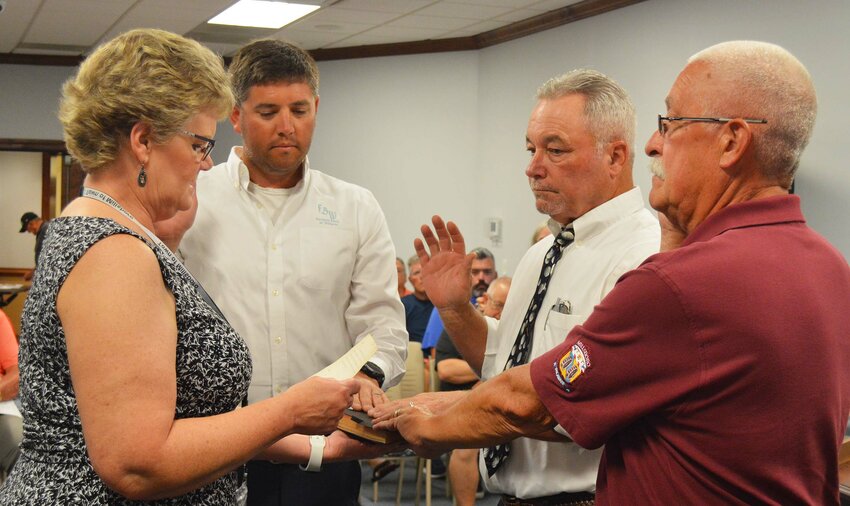Millsboro town clerk Joanne Dorey administers the oath to council members, from left, Matthew Davis, Marty Presley and Ron O'Neal at Monday's Town Council meeting.
