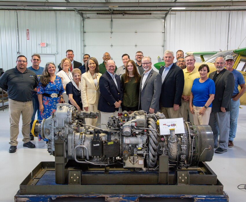 (Center, from left) U.S. Rep. Lisa Blunt Rochester, D-Del., U.S. Sen. Chris Coons, POLYTECH School of Aviation apprentice Abigail Holloway, Piedmont Airlines President and CEO Eric Morgan and Piedmont aircraft maintenance director Kurt Yorgey pose for a photo with a turboprop engine that Piedmont donated to the aviation school in Dover on Thursday.