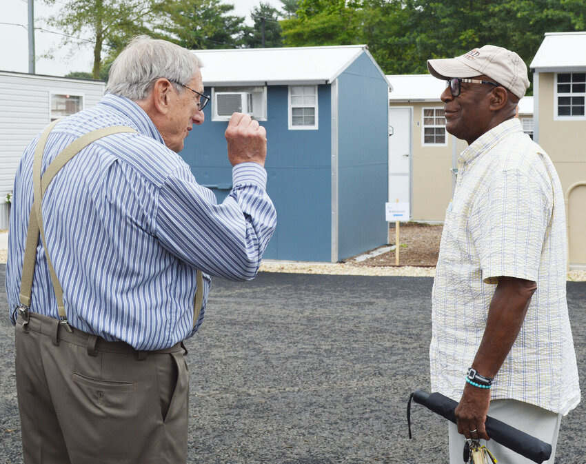 Springboard Collaborative Executive Director Judson Malone, left, speaks with Archie Campbell, mayor of the City of Milford at the Springboard Collaborative Pallet Shelter in Georgetown in early August.